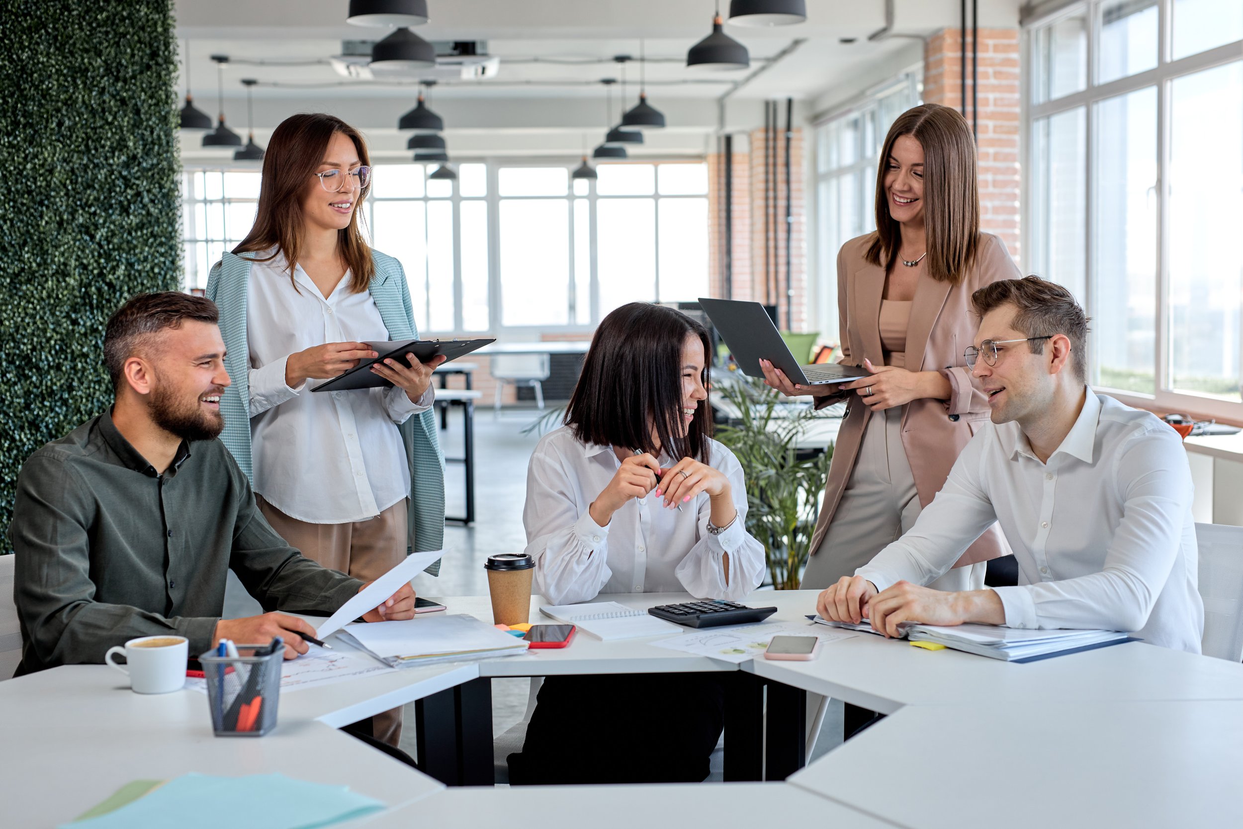 Des personnes réunies dans un espace de travail lumineux et végétalisé