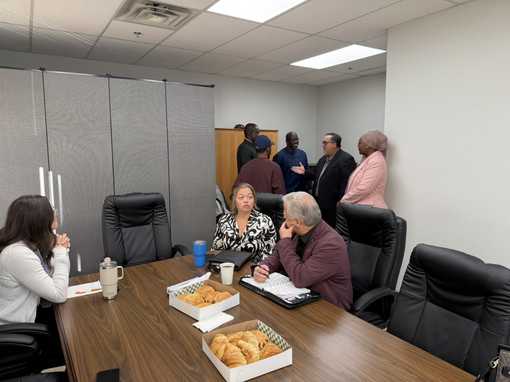 Participants réunis autour d’une table et échangeant dans une salle de réunion