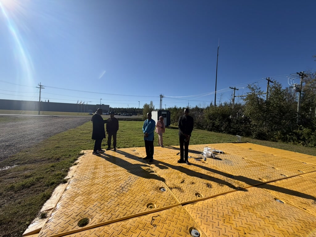 Participants debout sur une plateforme modulaire jaune à l’extérieur